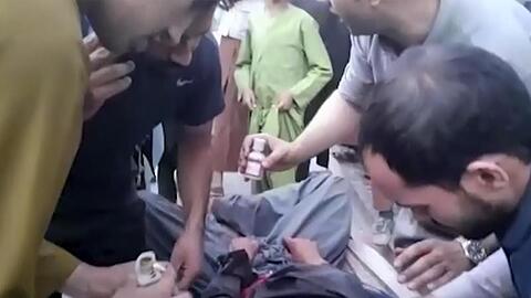 Ein Screenshot aus einem Video zeigt Menschen, die sich um einen Verwundeten in der Nähe des Explosionsortes kümmern.