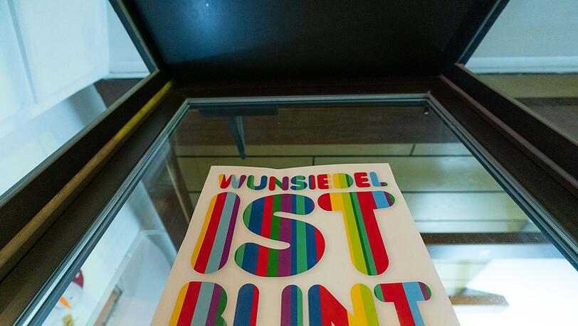 An einer Fensterfront eines Geschäftes ist ein Plakat mit der Aufschrift "Wunsiedel ist bunt" angebracht.