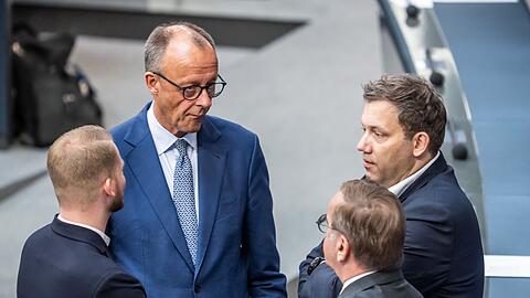 Versöhnliche Tonlage: Kanzler Merz spricht mit SPD-Generalsekretär Klüssendorf (links) und SPD-Chef Klingbeil (ganz rechts) im Bundestag. (Archivbild)