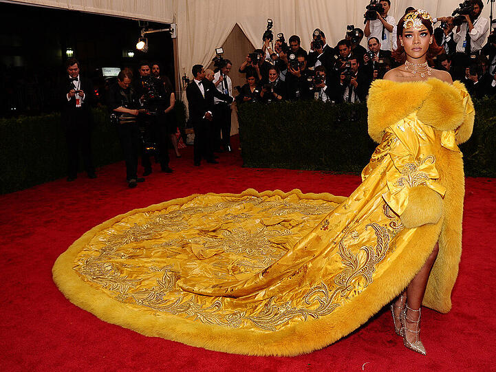 Alles anders als halbnackt tauchte Rihanna in New York auf. Dafür präsentierte sie sich in einer gelben, bestickten und mit Pelz besetzten Robe von Guo Pei, die die längste Schleppe vorzuweisen hatte. Auf dem Kopf trug sie goldenen Haarschmuck.