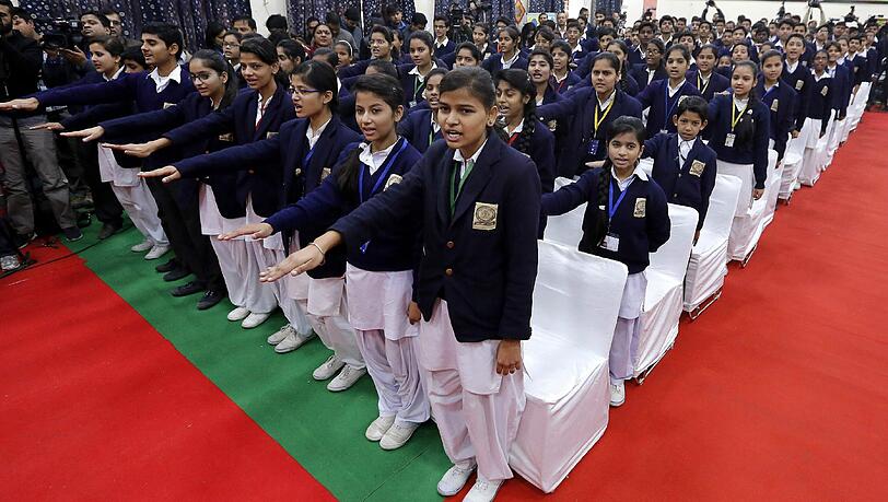 Schulkinder in Neu-Delhi begrüßen ihren Minister (nicht im Bild).