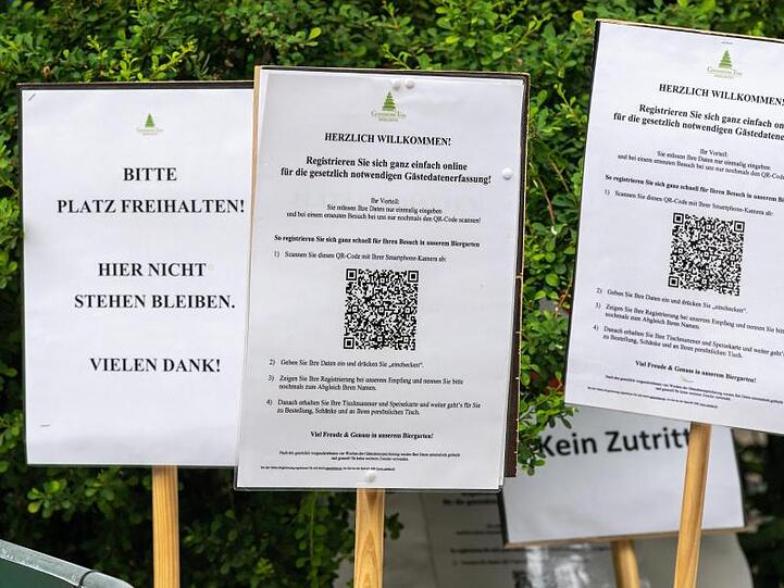 In der Corona-Krise: diverse Hinweisschilder vor einem Biergarten in Münchens Englischem Garten.