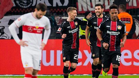 Leverkusens Doppeltorschütze Kevin Volland (2.v.l. jubelt mit Mitchell Weiser, während ein Stuttgarter den Kopf hängen lässt.