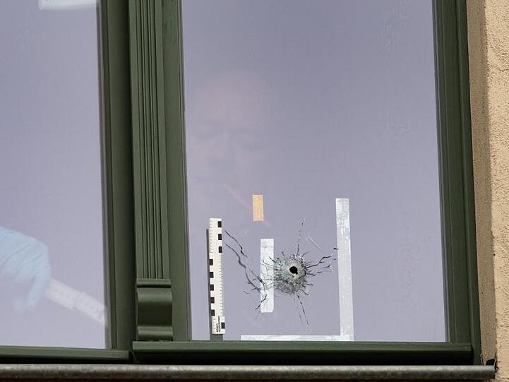 Mörderischer Antisemitismus: Ein Beamter der Spurensicherung untersucht ein Einschussloch in einem Fenster in einem Haus gegenüber der Synagoge von Halle/Saale.