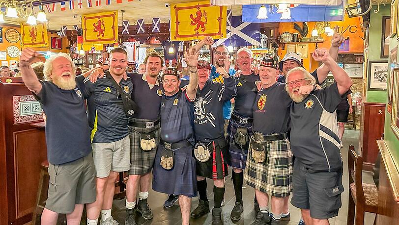 Thomas Patterson (4. von links) und Colin O'Hara (5. von links) feiern mit ihren Freunden im Irish Pub Kennedy's Bar und Restaurant. Sie begleiten die schottische Fußballnationalmannschaft bei all ihren Spielen bei der Europameisterschaft. Foto: privat