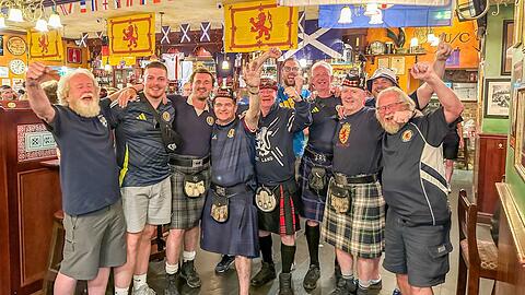 Thomas Patterson (4. von links) und Colin O'Hara (5. von links) feiern mit ihren Freunden im Irish Pub Kennedy's Bar und Restaurant. Sie begleiten die schottische Fußballnationalmannschaft bei all ihren Spielen bei der Europameisterschaft. Foto: privat