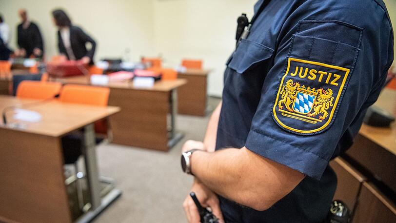 Ein Justizbeamter steht zu Beginn eines Prozesses im Sitzungssaal vor dem Landgericht München II. (Symbolbild)