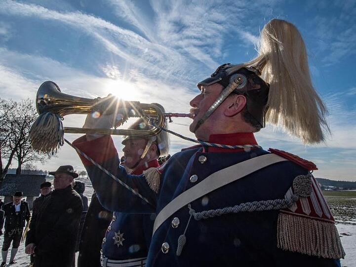 Ein Königstreuer in historischer Uniform bläst am Denkmal für die Schlacht von Gammelsdorf auf der Trompete. Foto: Armin Weigel/dpa/Archiv