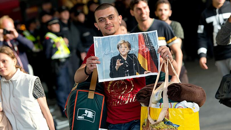 Hoffnungsort Deutschland: Ein Flüchtling zeigt am Münchner Hauptbahnhof ein Foto von Angela Merkel.