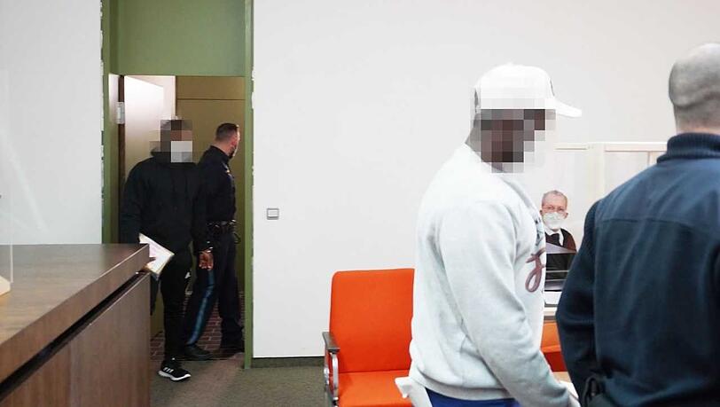 Die beiden Angeklagten werden zur Anklagebank geführt.