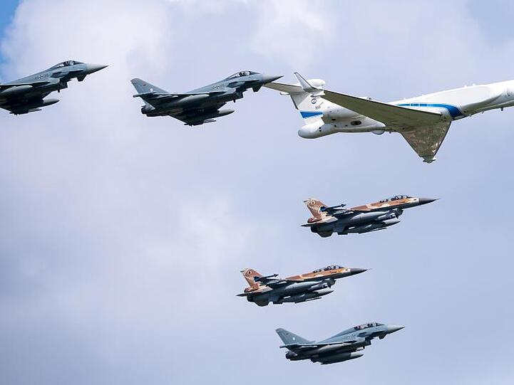 Zwei Jagdflugzeuge der israelischen Luftwaffe (IAF), drei Eurofighter der Bundeswehr (grau) und ein Learjet der israelischen Luftwaffe fliegen über den Fliegerhorst Fürstenfeldbruck. Foto: Sven Hoppe/dpa
