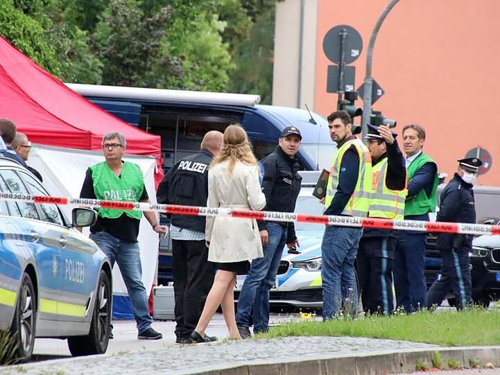 Polizisten steht am Tatort, an dem zuvor ein Mann erschossen wurde. Foto: Alexander Auer/Alexander Auer/dpa/dpa