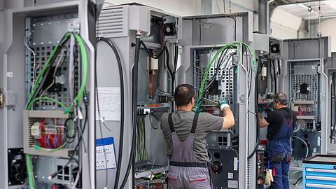 Mitarbeiter verdrahten Ladesysteme von Siemens für Elektroautos.