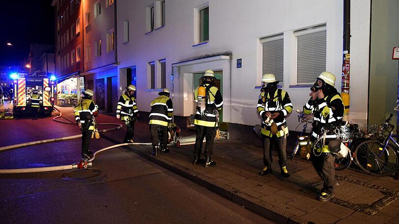 Feuerwehrleute dringen in die verqualmte Wohnung vor.