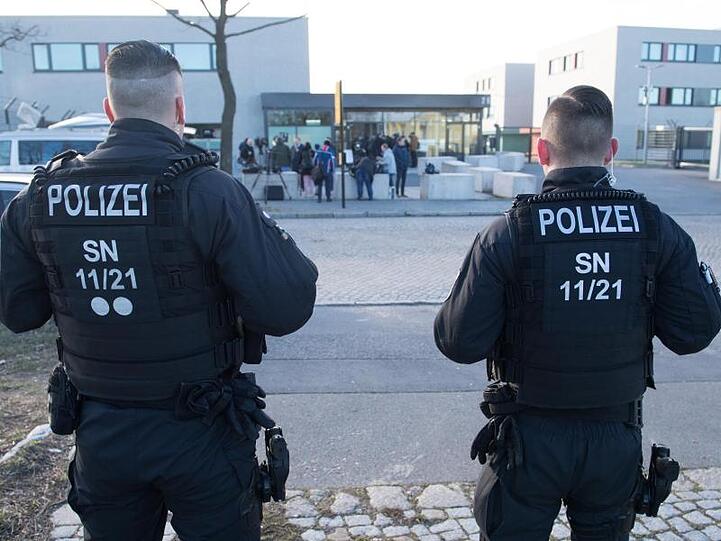 Zwei Polizisten stehen vor dem Oberlandesgericht Dresden, in dem der Prozess um die tödlichen Messerstiche von Chemnitz beginnt.