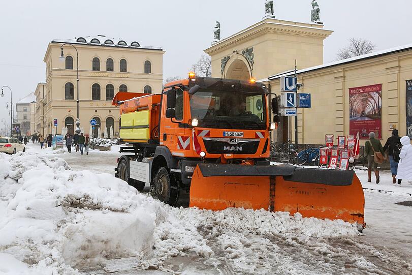 Am Odeonsplatz schippt ein Räumfahrzeug die Schneemassen auf die Seite.