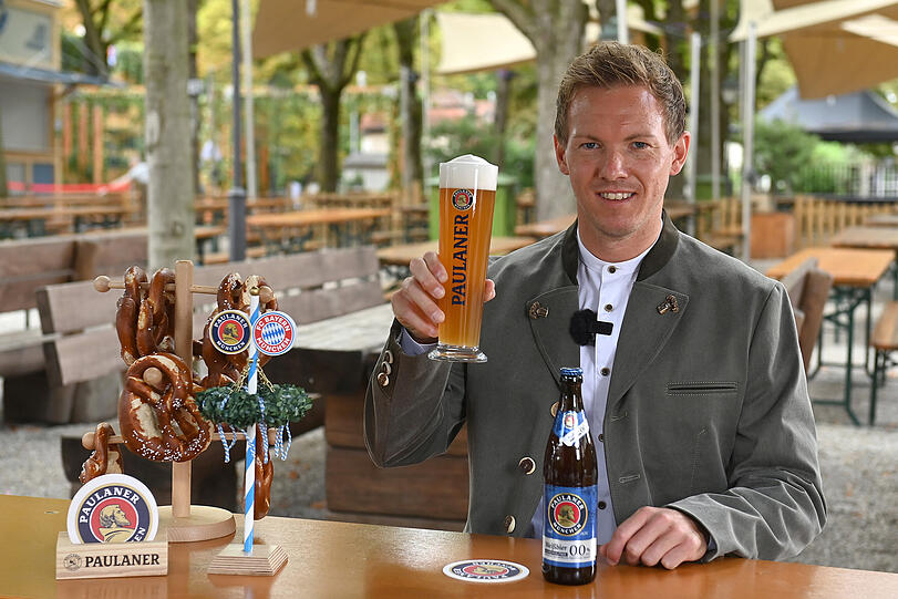 Trainer Julian Nagelsmann prostet mit einem Bier beim FC Bayern München Paulaner  "Lederhosen-Shooting" im Paulaner am Nockherberg zu.