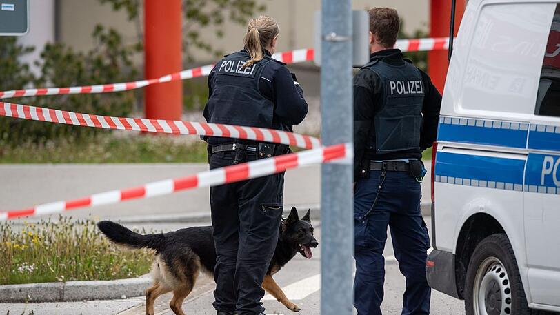 Zwei Polizisten mit einem Sprengstoff-Spürhund stehen vor dem Einkaufszentrum HEP.