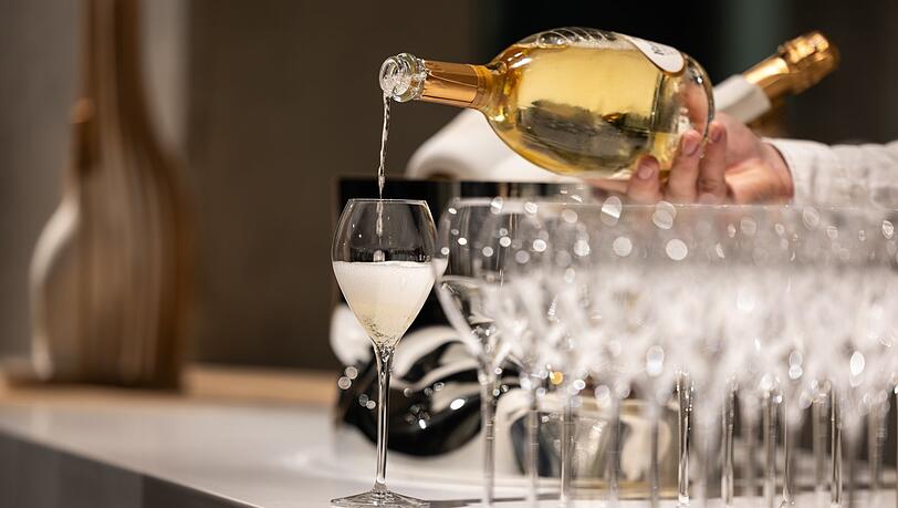 Ein Kellner schenkt ein Glas Champagner ein. Ein Kellner schenkt ein Glas Champagner ein.