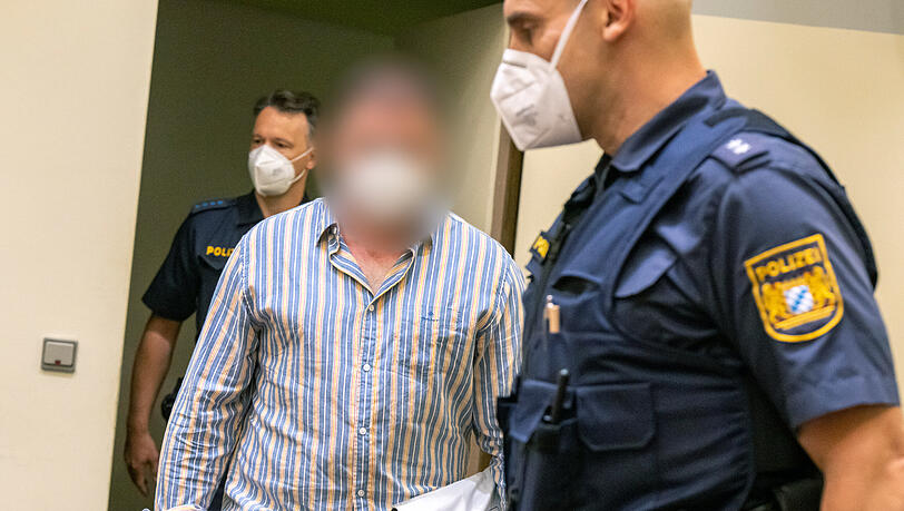 Der Angeklagte wird von der Polizei in den Gerichtssaal geführt.