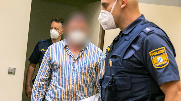 Der Angeklagte wird von der Polizei in den Gerichtssaal geführt.