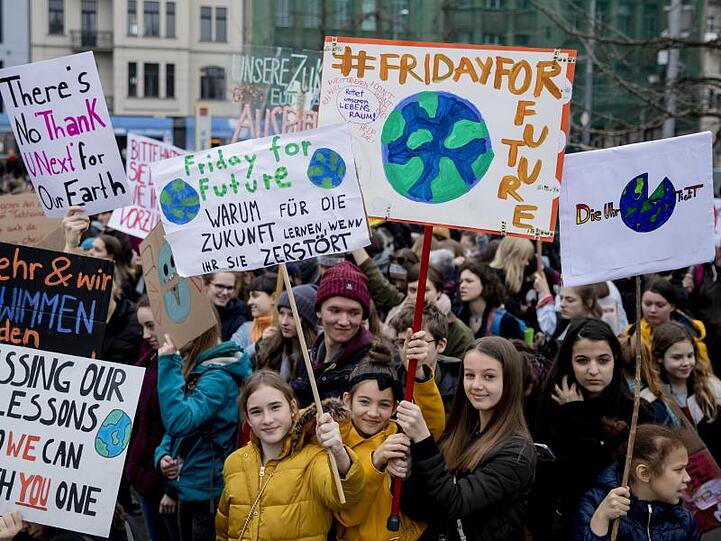 Jugendliche Teilnehmer der Klima-Kundgebung "Fridays for Future" stehen mit Plakaten am Berliner Invalidenpark und fordern eine bessere Klimapolitk.