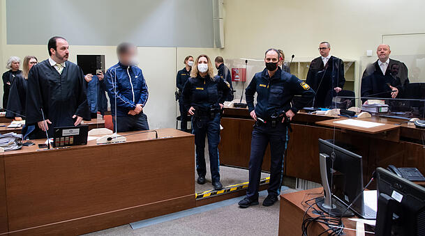 Drei Männer, die wegen illegalen Waffenhandels angeklagt sind, stehen vor Prozessbeginn im Verhandlungssaal. Drei Männer, die wegen illegalen Waffenhandels angeklagt sind, stehen vor Prozessbeginn im Verhandlungssaal.