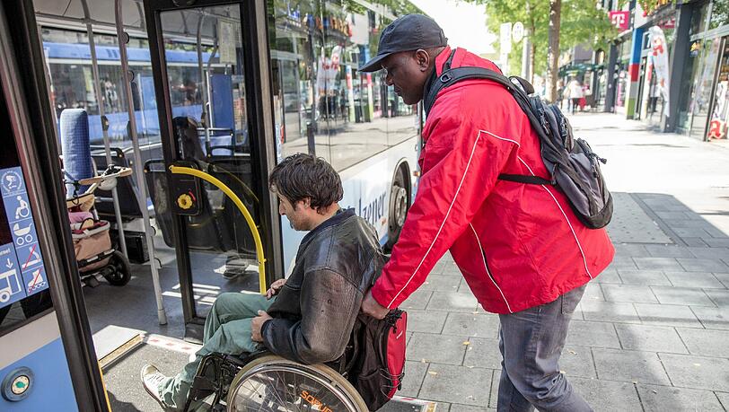 Gut erkennbar in roten Jacken unterstützen ab Montag Mobilitätshelfer Menschen mit Behinderung bei ihrem Weg durch die Stadt. Gut erkennbar in roten Jacken unterstützen ab Montag Mobilitätshelfer Menschen mit Behinderung bei ihrem Weg durch die Stadt.