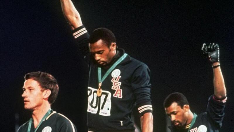 Die US-Athleten Tommie Smith (M) und John Carlos (r) streckten während Olympia 1968 die Fäuste, um gegen Rassismus zu protestieren. Die US-Athleten Tommie Smith (M) und John Carlos (r) streckten während Olympia 1968 die Fäuste, um gegen Rassismus zu protestieren.
