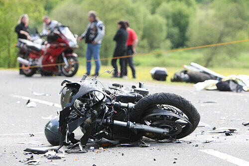Die total zerstörte Honda des Verursacher blieb auf der Straße liegen, das Bike des Opfer wurde in die Wiese geschleudert. Die Freunde des Toten (im Hintergrund) warteten, bis der Leichenwagen kam.