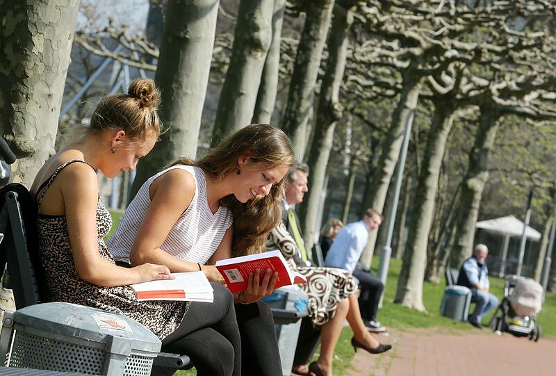 Lisa (l) und Katrin, Medizinstudentinnen im letzten Semester, lernen an der Rheinuferpromenade in Düsseldorf bei herrlichem Frühlingswetter für eine Prüfung.