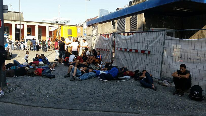 Völlig erschöpft rasten die Flüchtlinge auf dem Bahnhofsvorplatz an der Arnulfstraße und warten auf ihre Registrierung.