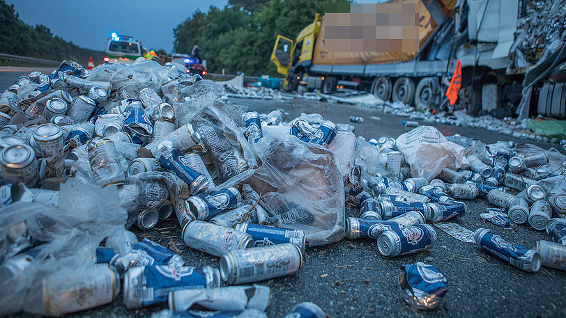 Die A9 ist ein einziges Schlachtfeld: Unzählige Bierdosen liegen nach dem Unfall auf der Fahrbahn verteilt. Beide Lkw-Fahrer kamen mit schwersten Verletzungen ins Krankenhaus.