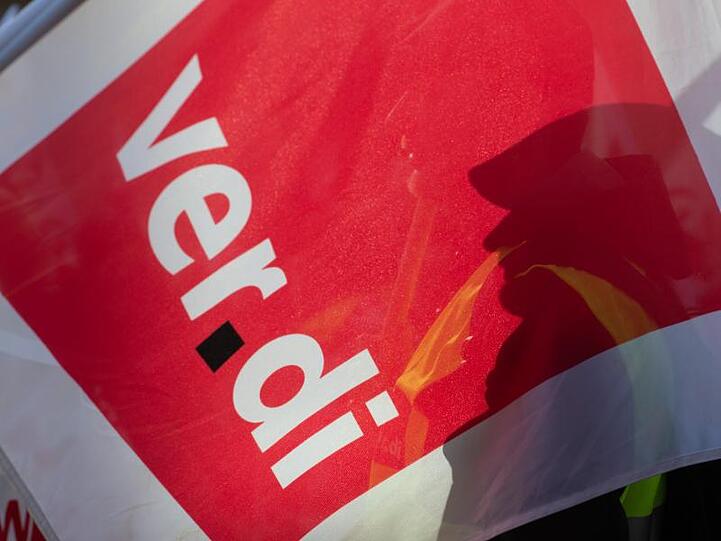 Der Schatten eines Teilnehmers am Warnstreik in Haöberstadt fällt auf eine Fahne der Gewerkschaft Verdi.