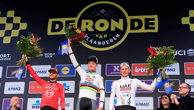Der Erstplatzierte Mathieu van der Poel (M) aus den Niederlanden feiert auf dem Podium mit dem Zweitplatzierten Luca Mozzato (l) aus Italien und Nils Politt.