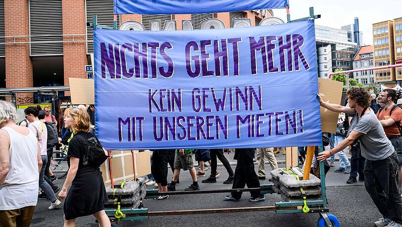Menschen protestieren gegen hohe Mieten. Laut dem neuen Bericht verschärfen diese die Armut. Menschen protestieren gegen hohe Mieten. Laut dem neuen Bericht verschärfen diese die Armut.