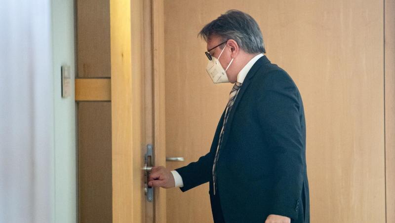 Georg Nüßlein (CSU) geht über einen Flur zu seinem Bundestagsbüro, während dort eine Durchsuchung stattfindet.