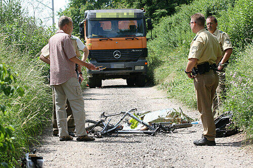 Ein Bild des Grauens: Gutachter und Polizisten stehen vor der Leiche des 13-jährigen Schülers und seinem Fahrrad. Im Hintergrund steht der Unglücks-Lkw.