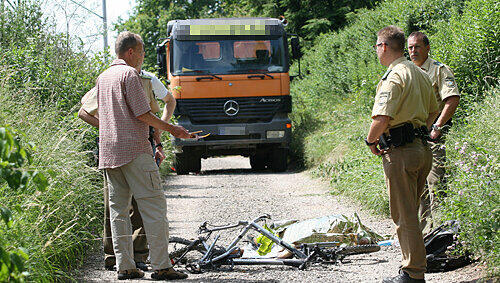 Ein Bild des Grauens: Gutachter und Polizisten stehen vor der Leiche des 13-jährigen Schülers und seinem Fahrrad. Im Hintergrund steht der Unglücks-Lkw. Ein Bild des Grauens: Gutachter und Polizisten stehen vor der Leiche des 13-jährigen Schülers und seinem Fahrrad. Im Hintergrund steht der Unglücks-Lkw.