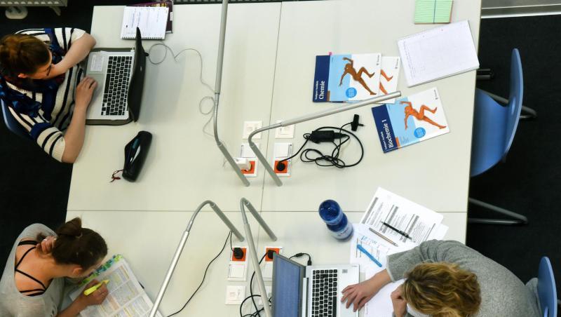Studenten sitzen an einem Tisch. Foto: Waltraud Grubitzsch/Archiv