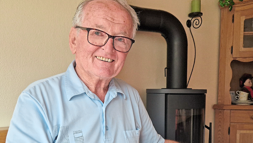 Kfz-Mechanikermeister Michael Aigner schaut durch ein jahrzehntealtes BMW-Fotoalbum und erinnert sich an die Anfangszeiten in Dingolfing.