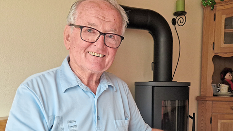 Kfz-Mechanikermeister Michael Aigner schaut durch ein jahrzehntealtes BMW-Fotoalbum und erinnert sich an die Anfangszeiten in Dingolfing.