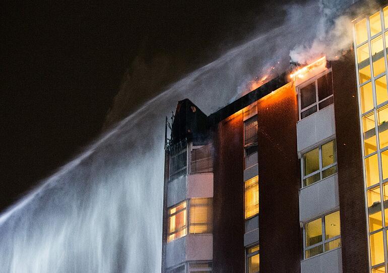 Aus den oberen Stockwerken eines Bochumer Krankenhauses schlagen hohe Flammen - 165 Feuerwehrleute bekämpfen das Feuer.