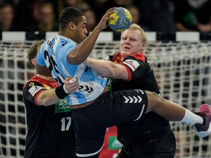 Steffen Weinhold (l) und Patrick Wiencek (r) kämpfen gegen Argentiniens James Lewis Parker um den Ball.