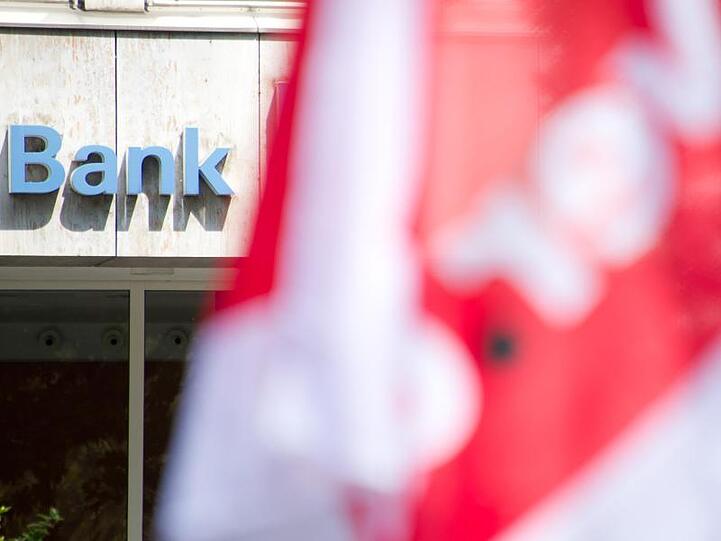 Verdi-Fahne vor einer Bank. Die Gewerkschaft hat Bankenwarnstreiks angekündigt.
