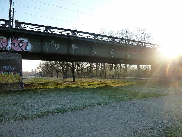 Die Braunuer Eisenbahnbrücke über die Isar, mit Blick auf die Wittelsbacherbrücke und die Kirche St. Maximilian.