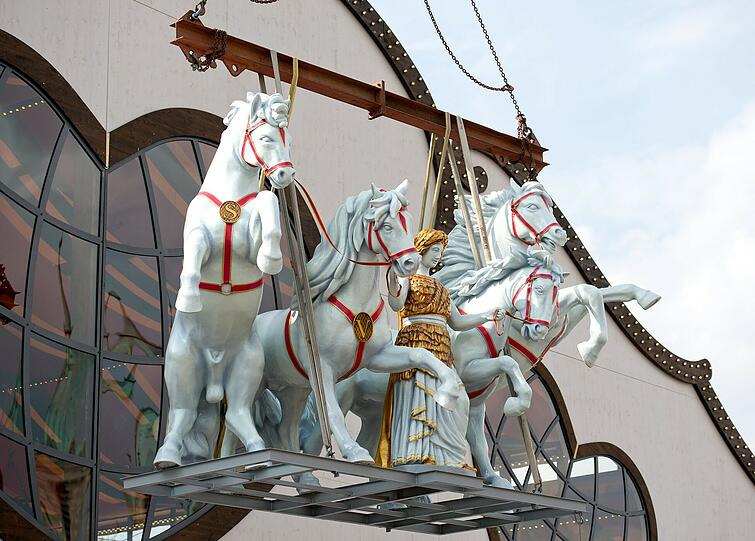 Die Bavaria zügelt vier wilde Schimmel auf dem Dach des Marstall-Zeltes.