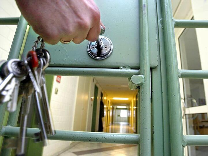 Ein Gefängnisgang ist zu sehen, hinter einer Tür, die abgeschlossen wird. Foto: Marcus Führer/Archiv