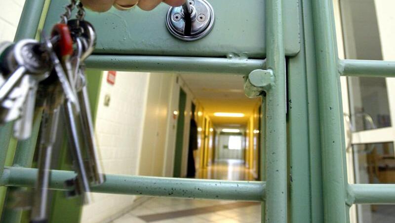 Ein Gefängnisgang ist zu sehen, hinter einer Tür, die abgeschlossen wird. Foto: Marcus Führer/Archiv