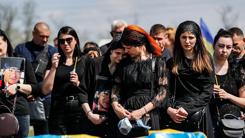Die 14-jährige Alexandria, ihre Mutter (M) und die 20-jährige Tochter Maria bei der Trauerfeier ihres Vaters im ukrainischen Dnipro. Der Soldat starb am Anfang Mai im Kampf gegen russische Soldaten in Charkiw. Die 14-jährige Alexandria, ihre Mutter (M) und die 20-jährige Tochter Maria bei der Trauerfeier ihres Vaters im ukrainischen Dnipro. Der Soldat starb am Anfang Mai im Kampf gegen russische Soldaten in Charkiw.